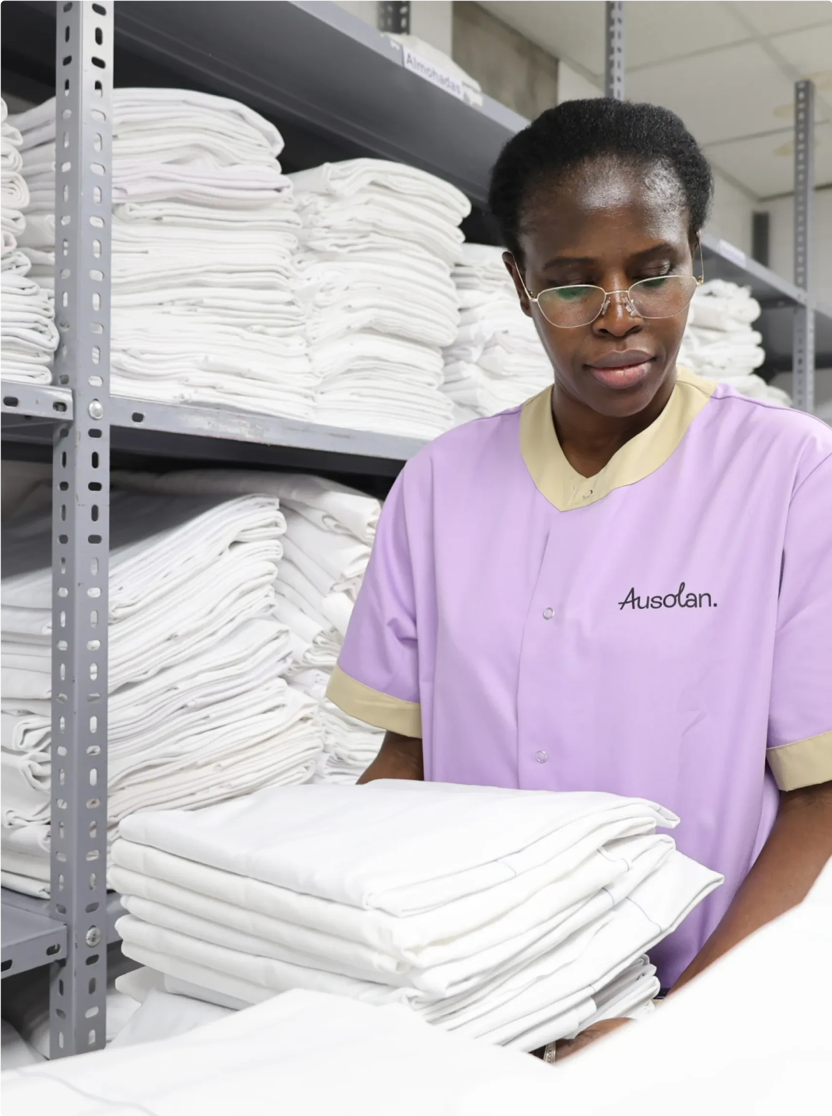 Mujer con uniforme de Ausolan recogiendo toallas