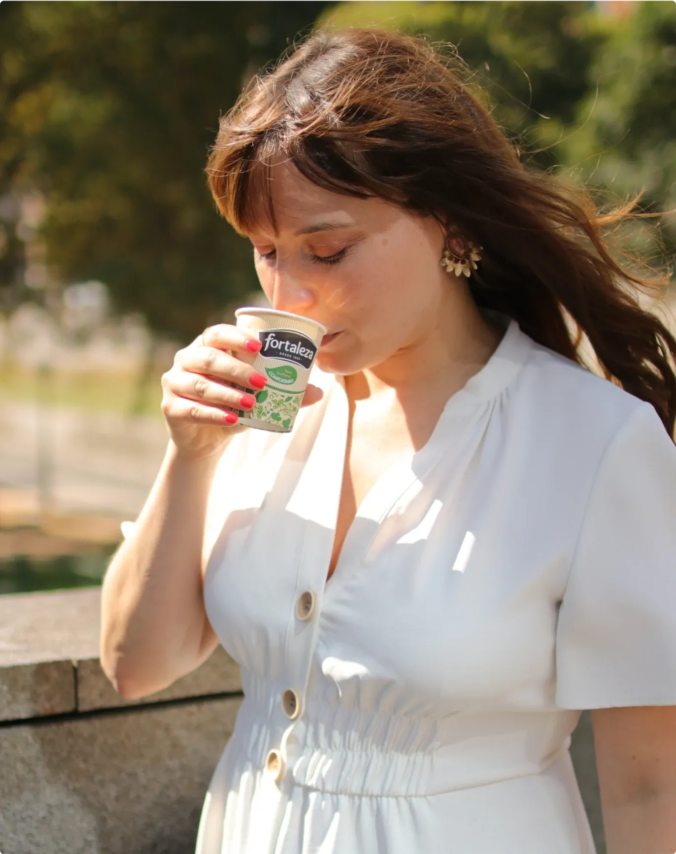 Chica de blanco bebiendo café en vaso de Café Fortaleza
